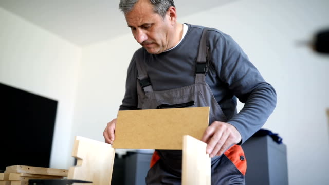 Man assembling wooden drawer for new home