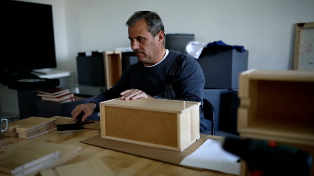 Man assembling wooden drawers for new home
