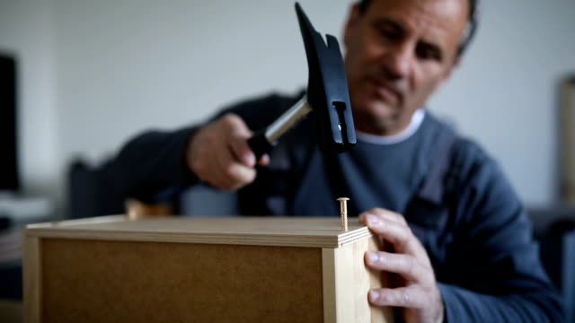 Man assembling wooden drawers