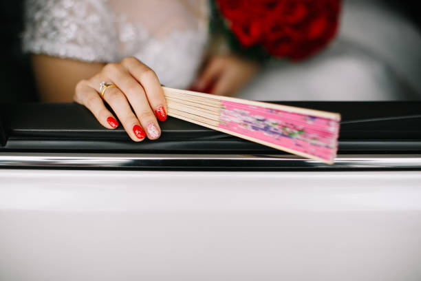 Bride holding hand fan for traditional Chinese wedding ceremony