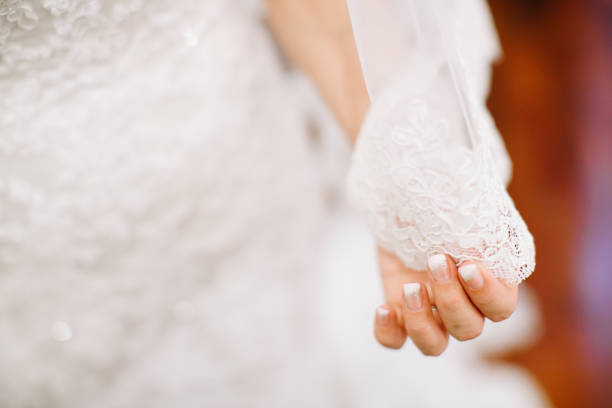 istock bride in wedding dress holding veil 1144984743