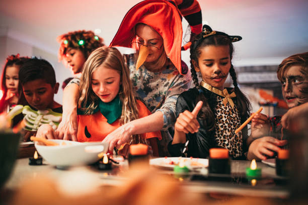 Deciding What To Eat Children sitting in a line deciding which foods to eat while at a Halloween party. They are all wearing costumes and one of the children is being helped by a parent food recall stock pictures, royalty-free photos & images