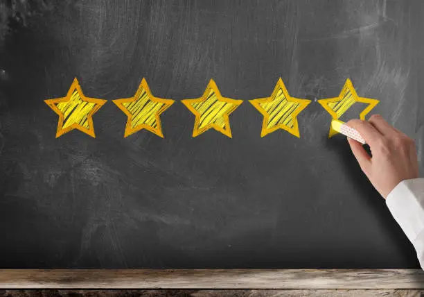 Photo of five star customer feedback or client service rating on blackboard