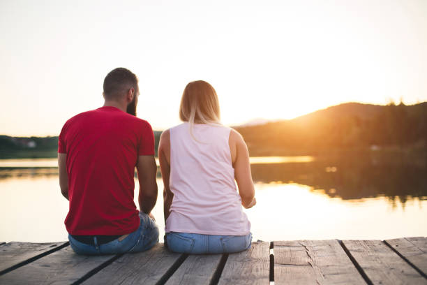 istock Romantic Couple sitting on the pier 1144988295