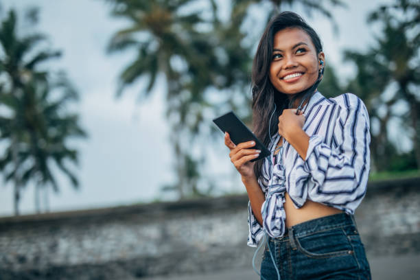 istock Modern woman using smart phone on the beach 1144989075
