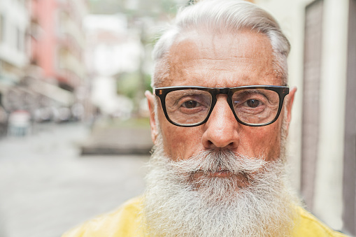 Portrait of hipster trendy man with serious expression - Close up of bearded senior guy - Fashion and elderly lifestyle concept - Focus on nose, mouth, glasses