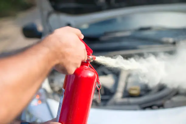 Man using car to extinguish a car fire. Close up shot