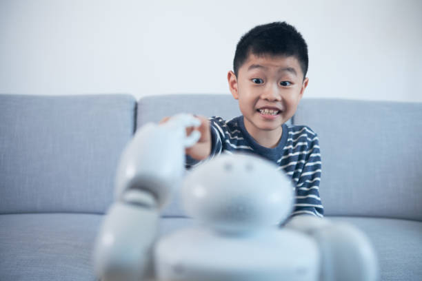 istock Smart boy touching robot finger indoors 1144992852