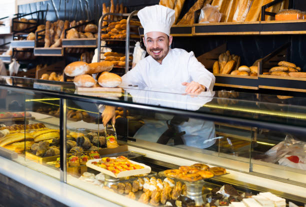 istock Cheerful baker showing assortment of bakery 1144994584