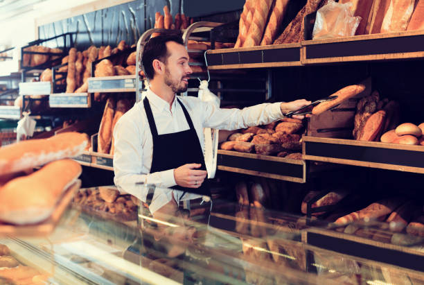 istock Seller offering fresh loaf of bread 1144994588