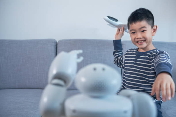 istock Smart boy showing model airplane with robot indoors 1144995286