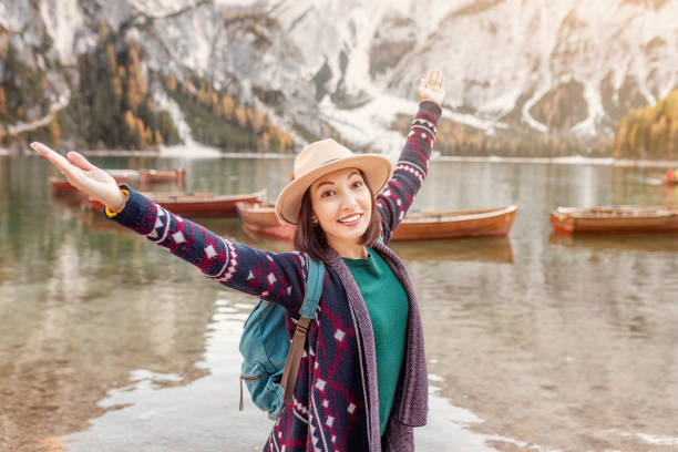 voyageur asiatique de femme sur la rive du célèbre lac touristique de braies dans les alpes de dolomites, italie. le concept de voyage et d’aventure dans les montagnes à la saison d’automne - asiatique du sud photos et images de collection