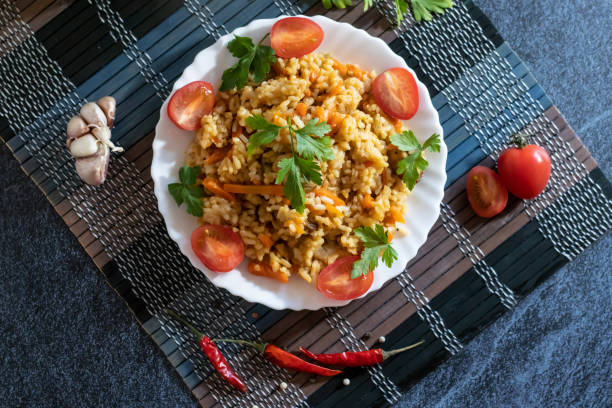 istock Pilaf and cherry tomatoes in a plate on a dark background. Central Asian cuisine. Horizontal orientation. Hot peppers 1144997400