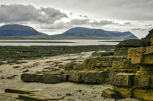 the hills of North Hoy across the Hoy channel from a sandy beach at Stromness  (The Ness)