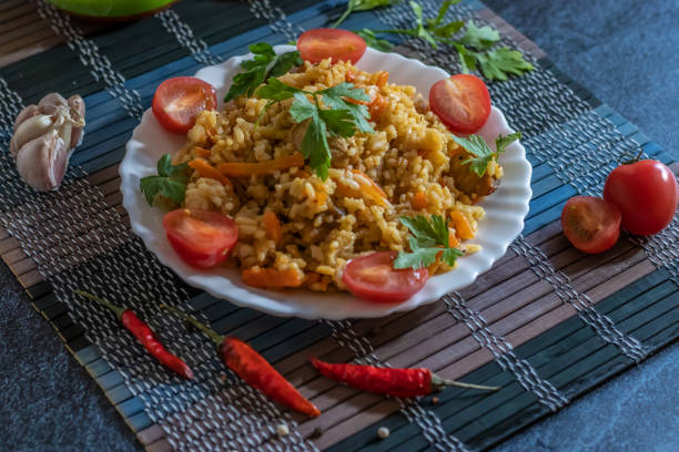 istock Pilaf and cherry tomatoes in a plate on a dark background. Central Asian cuisine. Horizontal orientation. Hot peppers 1144998772