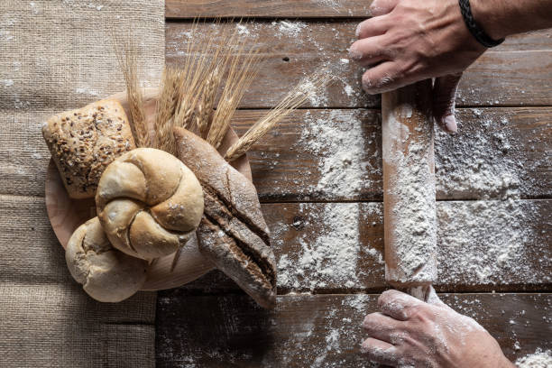 istock bread with wheat ears and flour on wood board, top view 1144999521