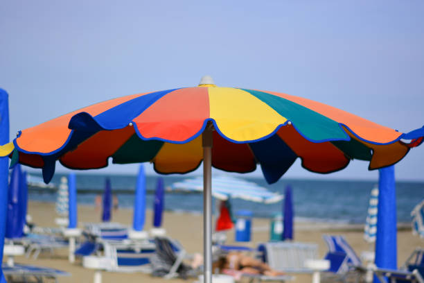 a beach umbrella with the colors of the rainbow Summertime san remo italy photos stock pictures, royalty-free photos & images