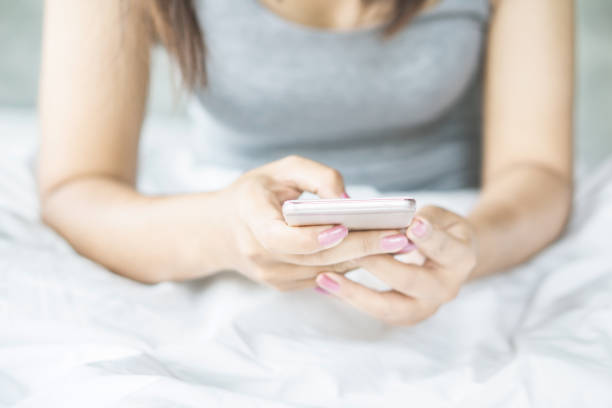 istock woman hand using smart phone on bed in the morning 1145001193