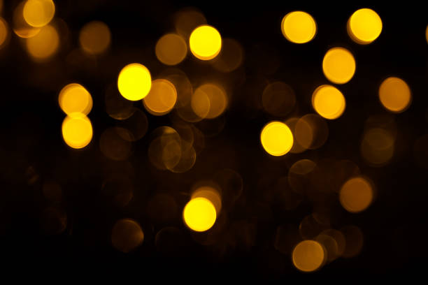 istock Abstract gold bokeh on black background. Defocused yellow lights, abstract texture 1145007165