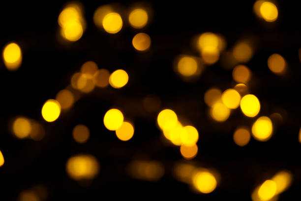 istock Abstract gold bokeh on black background. Defocused yellow lights, abstract texture 1145007314