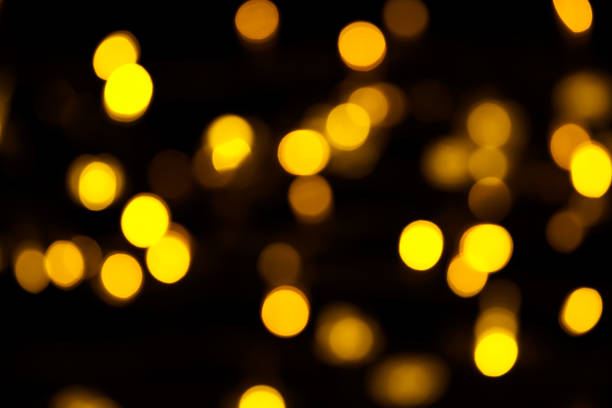istock Abstract gold bokeh on black background. Defocused yellow lights, abstract texture 1145007338