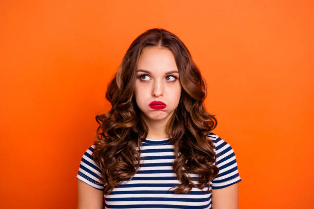 Close up photo beautiful she her lady red lipstick hold breath full mouth air ignore not listen speak talk tell look up wear casual striped white blue t-shirt clothes isolated orange bright background Close up photo beautiful she her lady red lipstick hold breath full mouth air ignore not listen speak talk tell look up wear casual striped white blue t-shirt clothes isolated orange bright background. nettle stock pictures, royalty-free photos & images