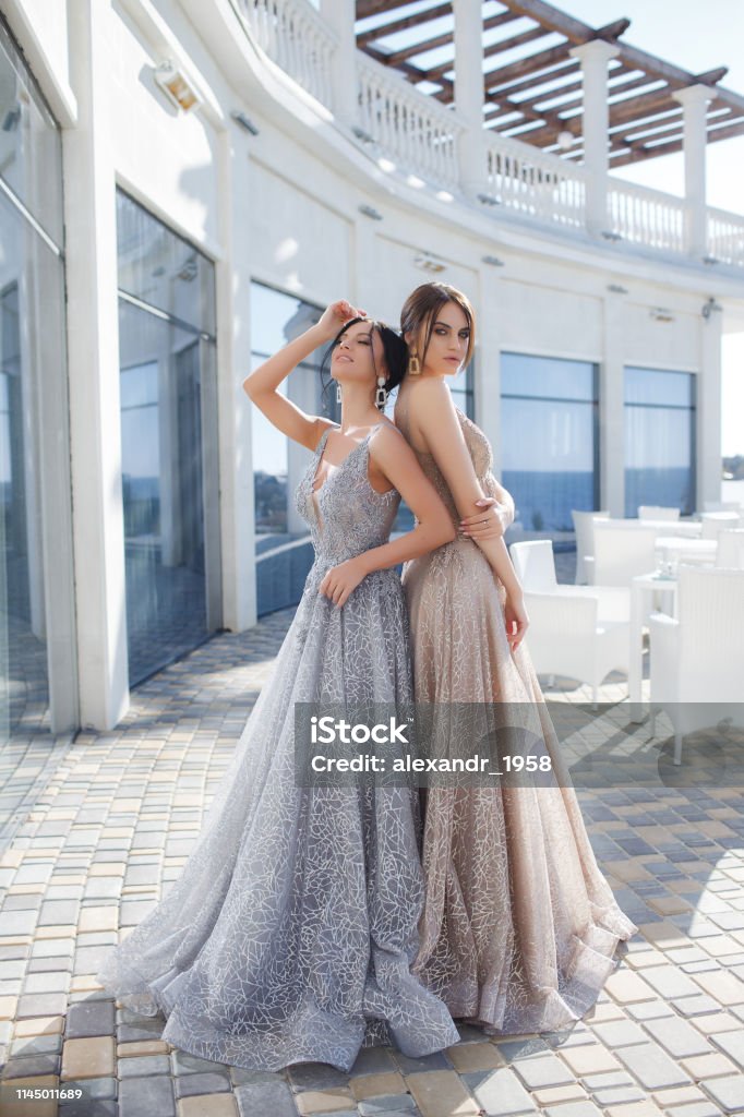 Dos Hermosas Mujeres Modelos Demuestran Vestidos De Noche Para Eventos Foto  de stock y más banco de imágenes de A la moda - iStock