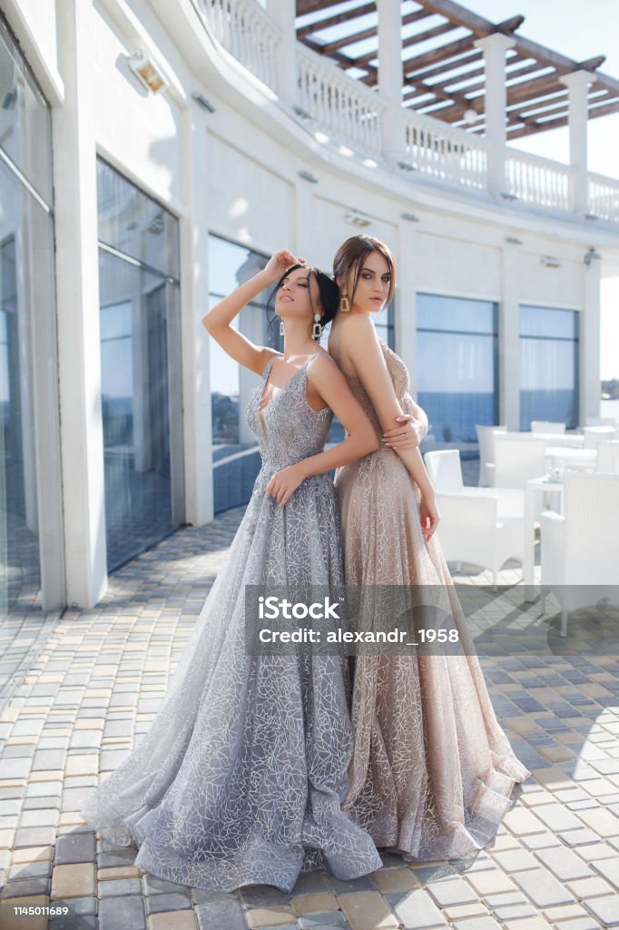 Dos Hermosas Mujeres Modelos Demuestran Vestidos De Noche Para Eventos Foto de stock y más banco de imágenes de A la moda - iStock Dos Hermosas Mujeres Modelos Demuestran Vestidos De Noche Para Eventos Foto de stock y más banco de imágenes de A la moda - iStock