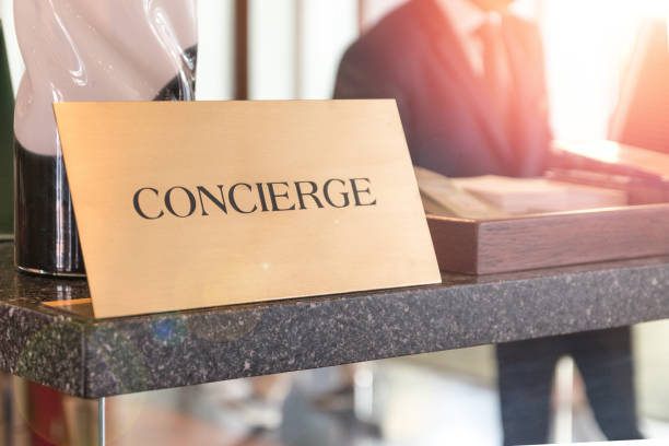 concierge service desk counter with happy employee staff receptionist working in front of hotel with tourist guest business customer. - hotel desk reception imagens e fotografias de stock