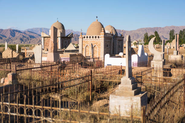 Central Asian Muslim cemetery with mountains in background, near Kochkor, Kyrgyzstan.