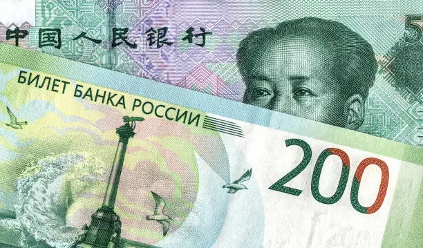 Photo of Chinese yuan banknote and russian rouble