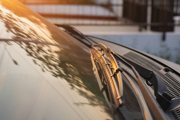Brushes on the car glass with copy space. The work of windshield wipers - brushes and an evening sunbeam