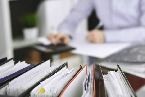 istock Unknown bookkeeper woman or financial inspector  making report, calculating or checking balance, close-up. Business portrait. Audit or tax concepts. 1145017334