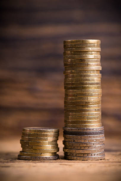 stacked coins showing income difference proportion between rich and normal incomes - incomes imagens e fotografias de stock