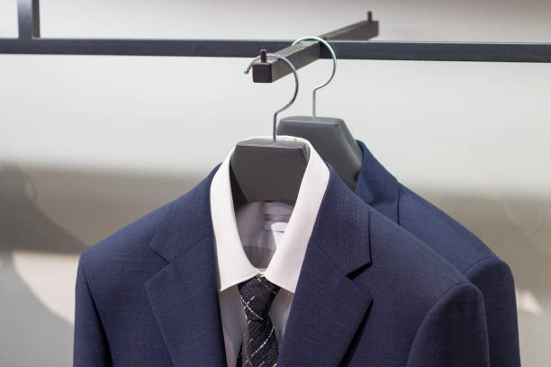 chaqueta azul en una percha, vista frontal de cerca, en la tienda de ropa para hombre. - lapel suit jacket necktie fotografías e imágenes de stock