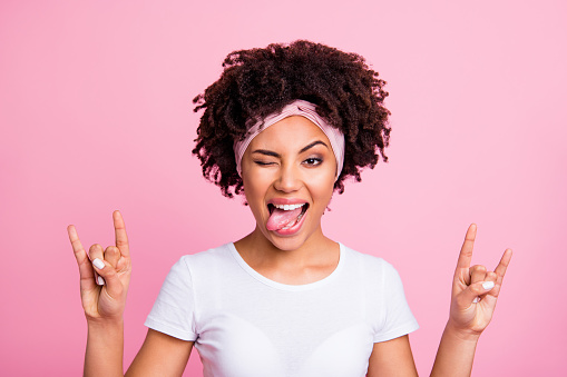 Close up photo amazing beautiful she her dark skin lady great cool event concert arms hands metal party tongue out mouth childish wear head scarf casual white t-shirt isolated pink bright background.