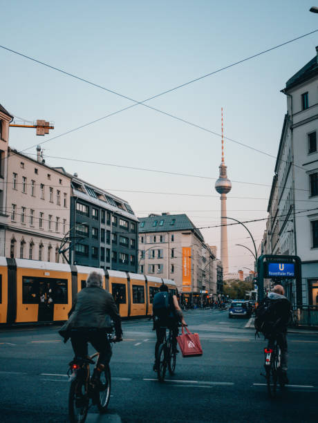 People riding along the tram in the very busy intersection at \