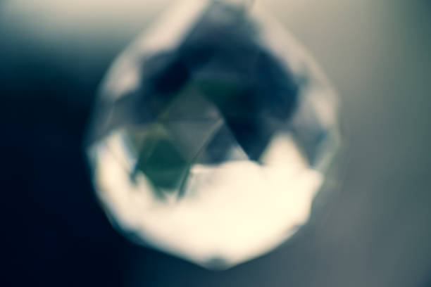 Out of focus image of light refracted through a glass crystal hanging on a window pane, refracting the light from a garden on the other side of the window.  Belfast, Northern Ireland.