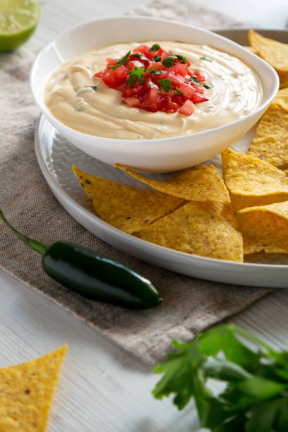 istock Homemade cheesy dip, yellow tortilla chips, side view. Closeup. 1145032245