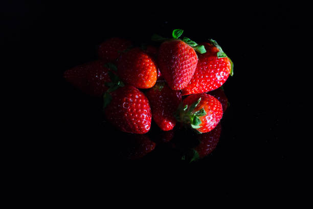 istock Fresh strawberries isolated on black background with reflections 1145032620