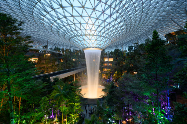 водопад дождь вортекс расположен внутри аэропорта jewel changi в сингапуре - changi стоковые фото и изображения