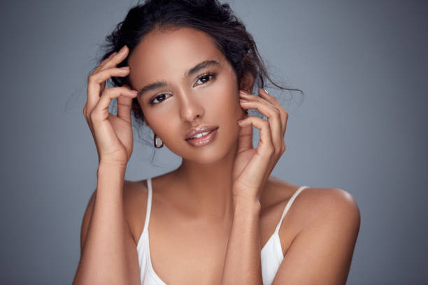 istock girl touching her face and looking to camera 1145034634
