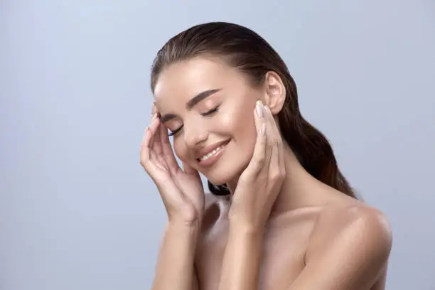 Photo of happy woman touching her face, girl smilling with close eyes, healthy happy face
