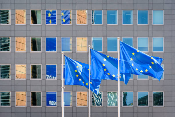 European flags blowing in the wind in front of the European Commission in Brussels, Belgium. Three european flags blowing in the wind at full-mast in front of the Berlaymont building, headquarters of the European Commission, the executive of the European Union (EU) in Brussels, Belgium. european union symbol stock pictures, royalty-free photos & images