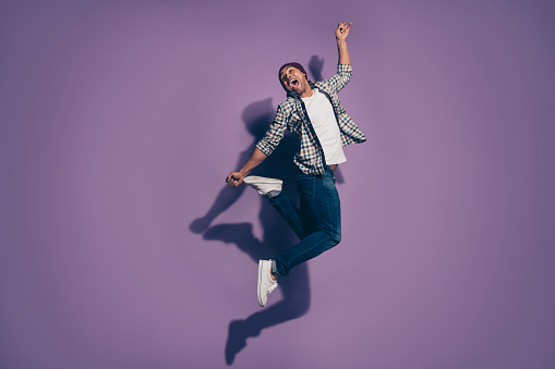 Full length body size photo of crazy nice handsome glad optimistic cool delightful in denim clothes person jumping up isolated violet background.
