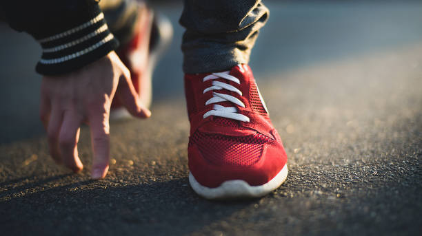 istock Cropped image of hands tying shoelaces on sneaker, running surface background. 1145039083