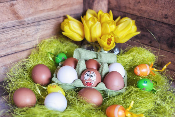 istock Easter composition with white and brown eggs in box with an egg plastered with a funny face 1145042141