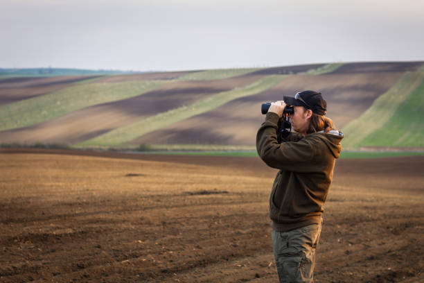 istock Hiking man looking for animals by binoculars in nature. 1145045026