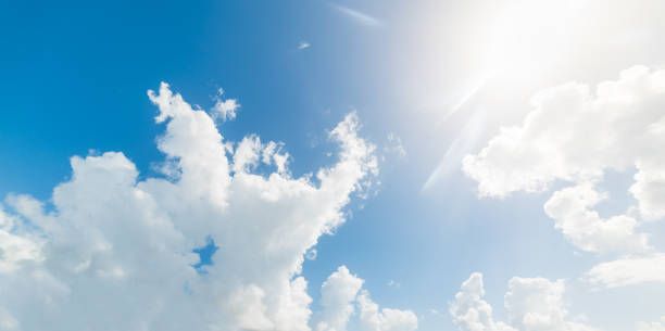 istock Sun shining over white clouds and blue sky 1145045637