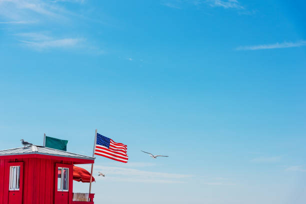 Seagulls flying over a red lifeguard tower in Siesta Key. Florida, USA